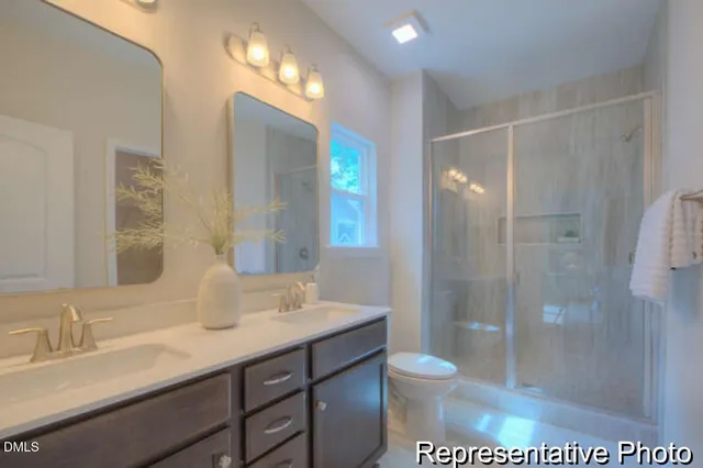 a bathroom with a granite countertop sink toilet a mirror and shower