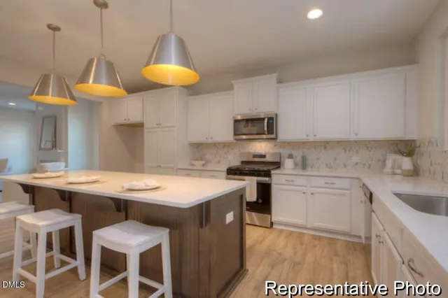 a kitchen with a table chairs sink and cabinets