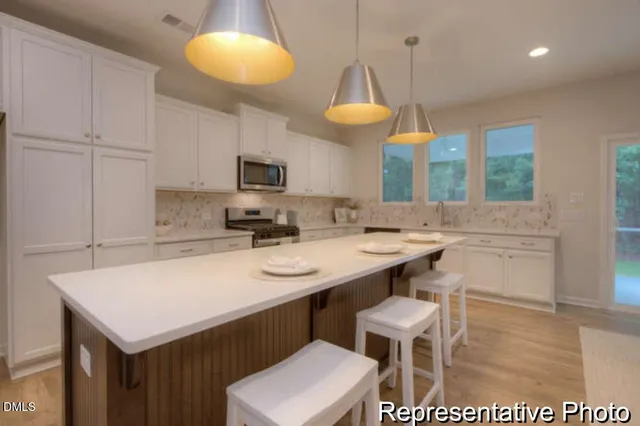 a kitchen with a sink cabinets and wooden floor