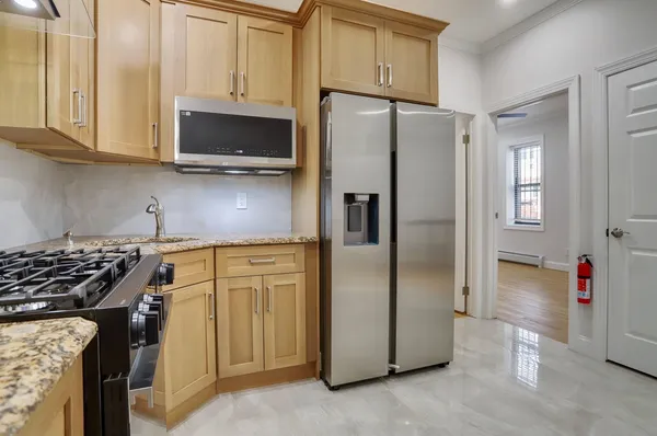 a kitchen with stainless steel appliances granite countertop a refrigerator stove and sink
