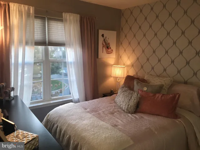 a large bed sitting in a bedroom next to a window