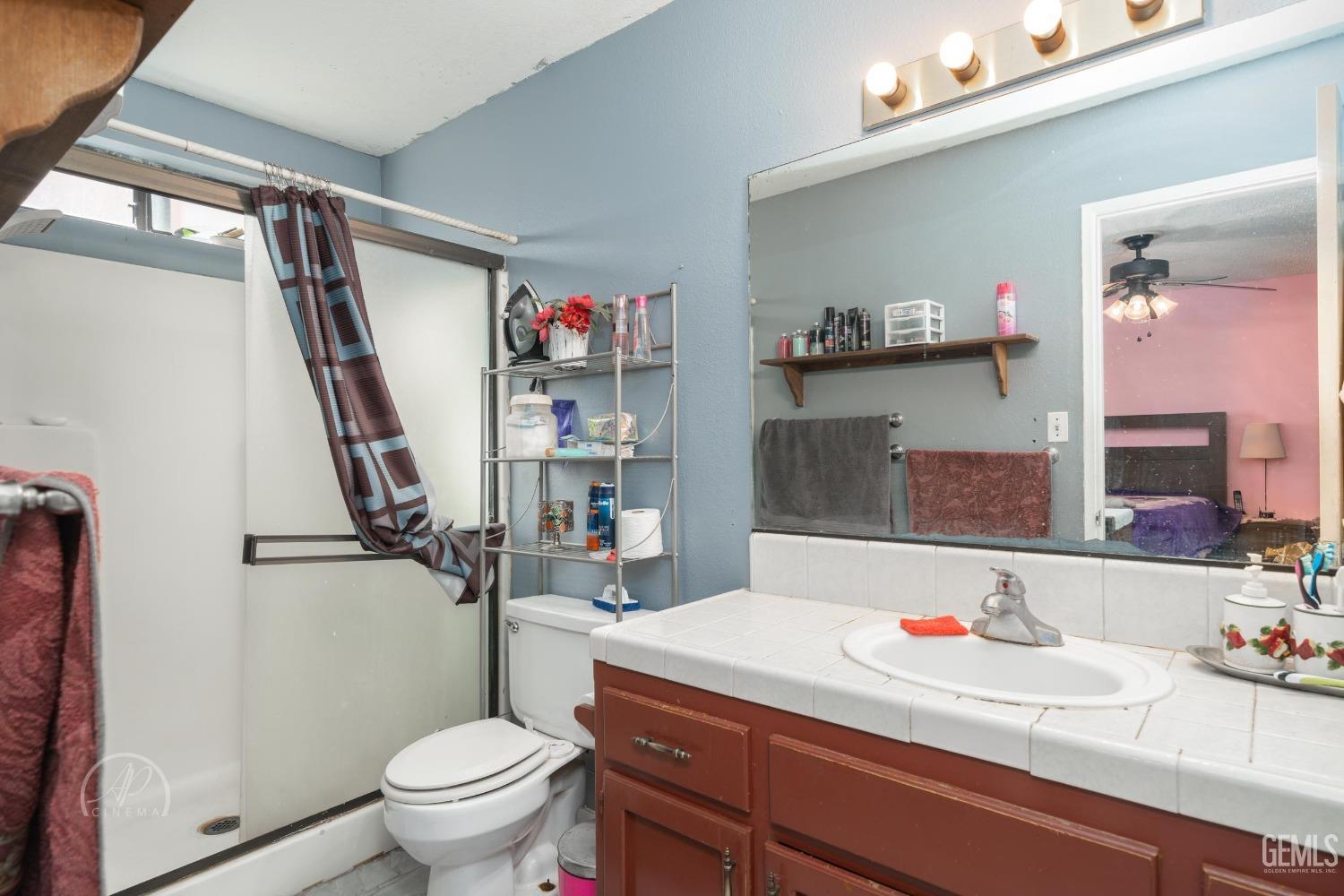 Undisclosed Address Bakersfield, CA 93307 - Photo 13 of 19 a bathroom with a sink a toilet and a mirror