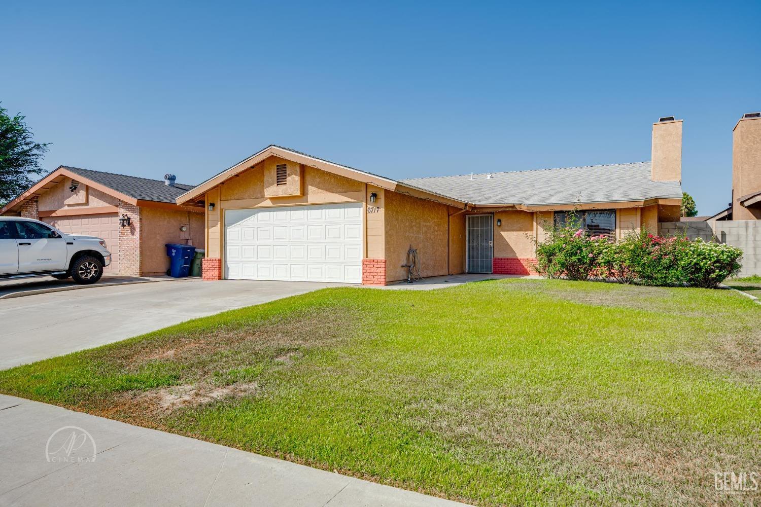 Undisclosed Address Bakersfield, CA 93307 - Photo 3 of 19 a front view of a house with a yard and garage