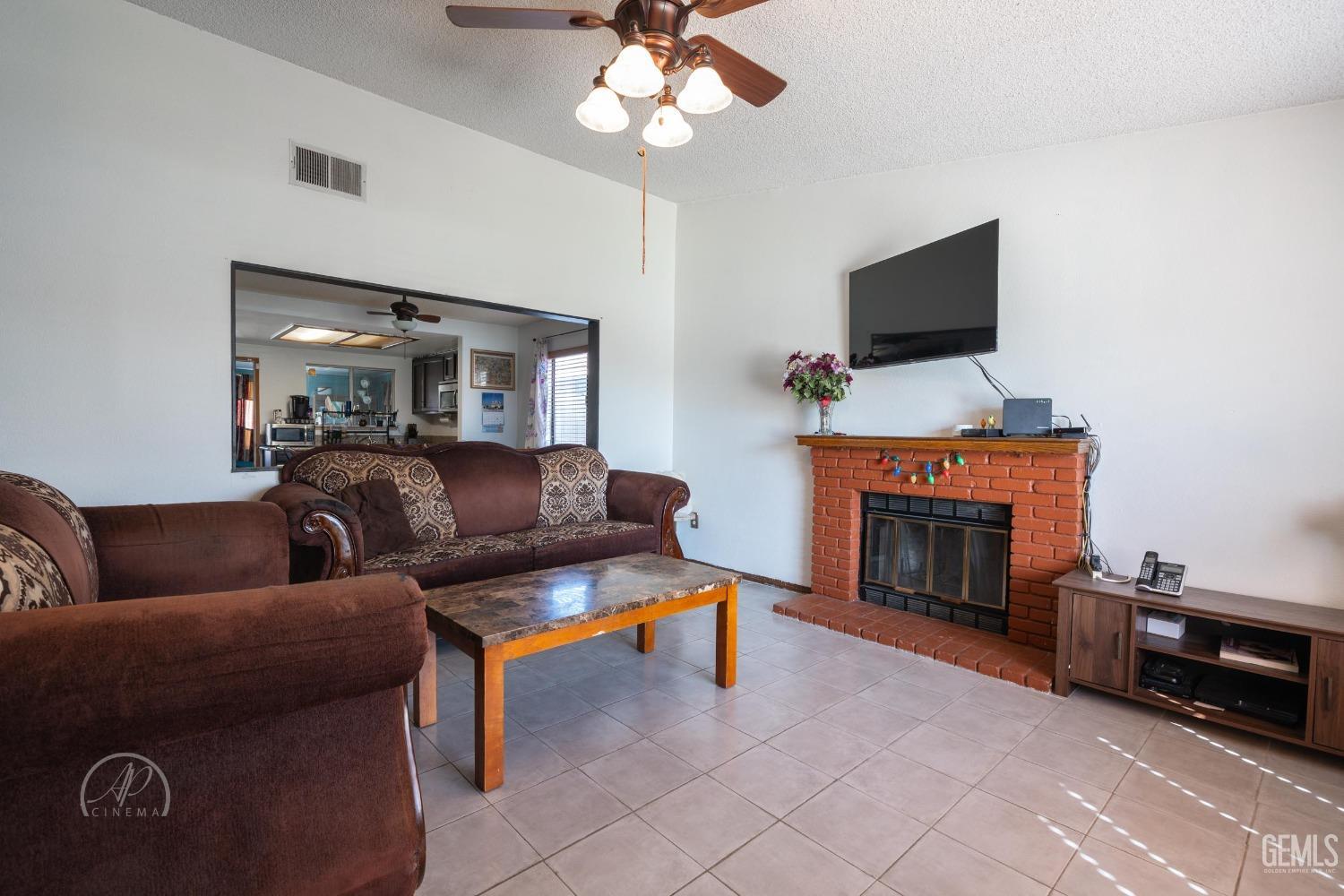 Undisclosed Address Bakersfield, CA 93307 - Photo 4 of 19 a living room with furniture a fireplace and a flat screen tv