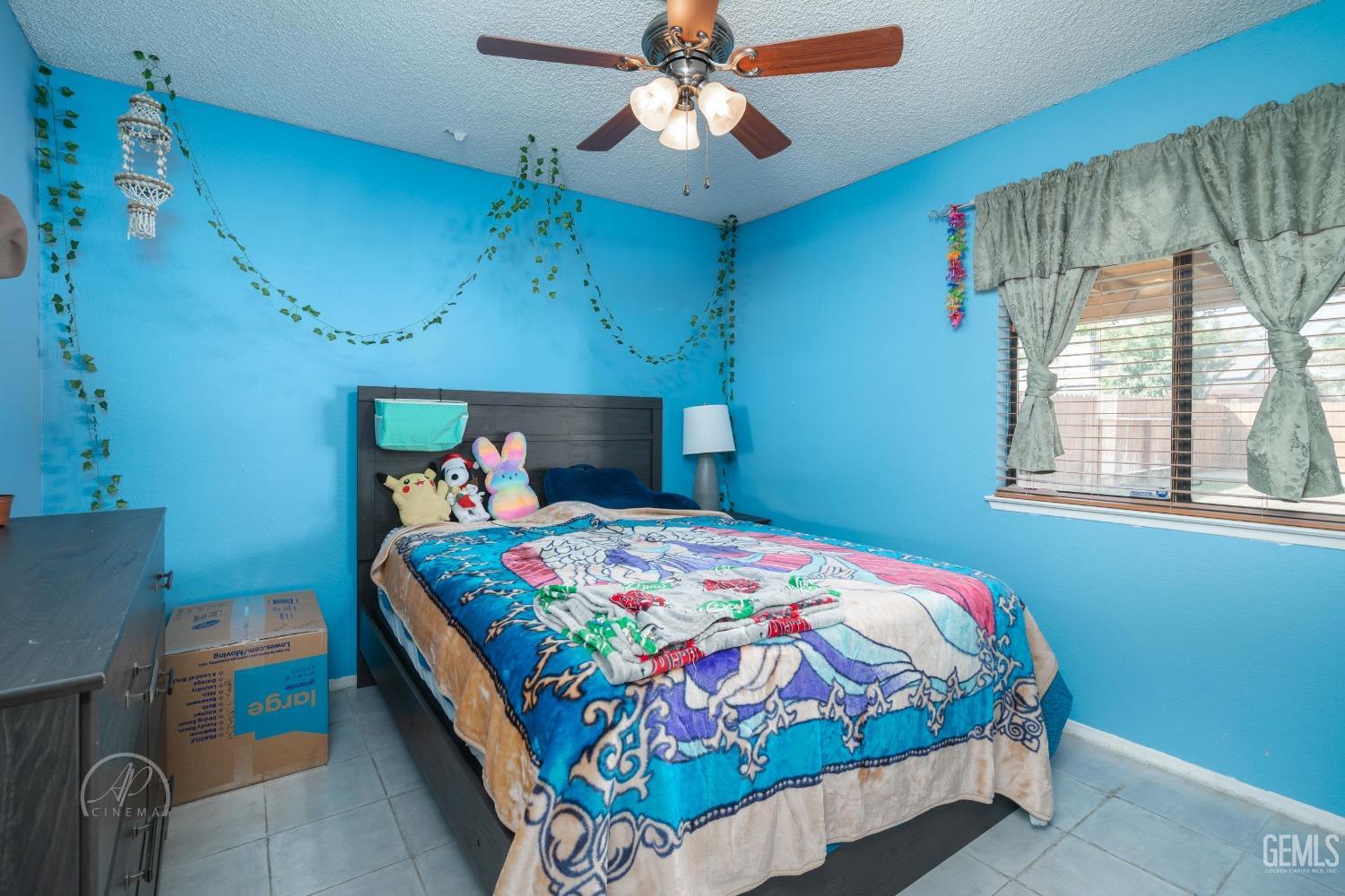 Undisclosed Address Bakersfield, CA 93307 - Photo 9 of 19 a bedroom with a bed a chandelier and a window