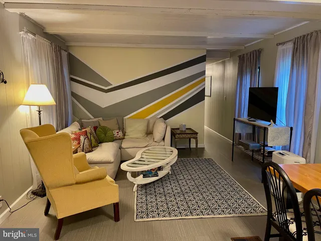 a living room with furniture a flat screen tv and a table