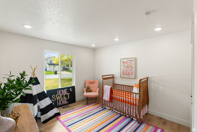 368 Spring Creek Road Providence, UT 84332 - Photo 21 of 45 Bedroom featuring light wood-style flooring, a textured ceiling, a nursery area, and recessed lighting