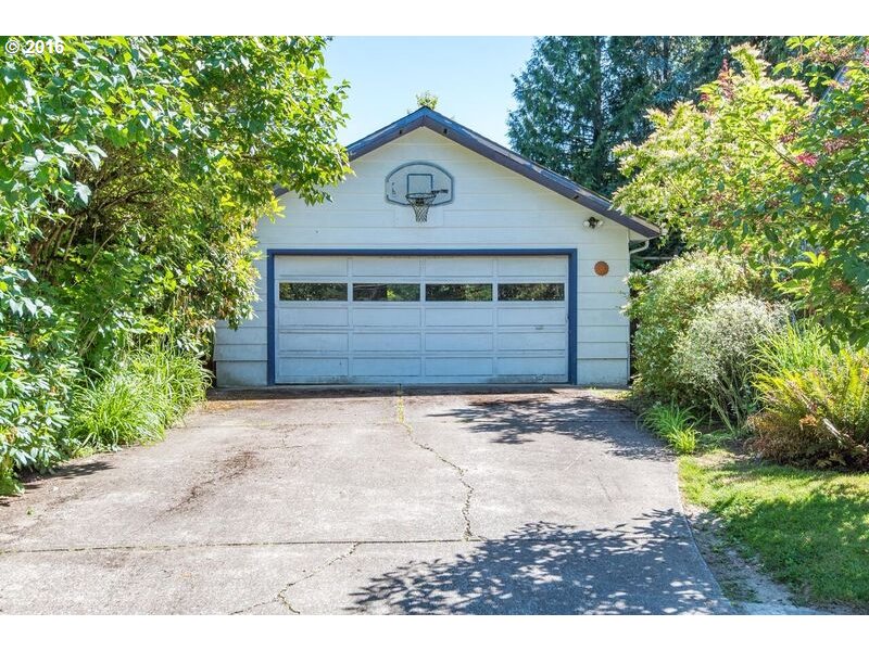 6026 Southwest Vermont Street Portland, OR 97219 - Photo 3 of 24 a front view of a house with a yard and garage