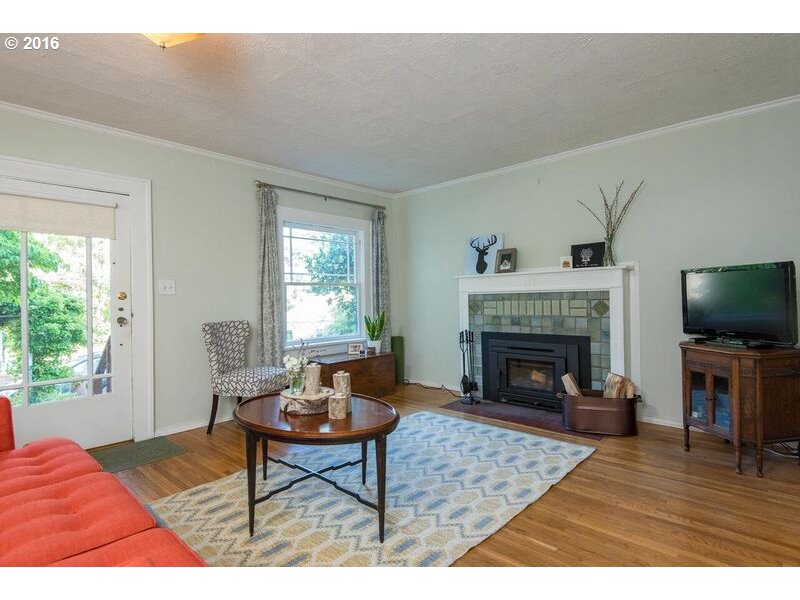 6026 Southwest Vermont Street Portland, OR 97219 - Photo 4 of 24 a living room with furniture a fireplace and a flat screen tv