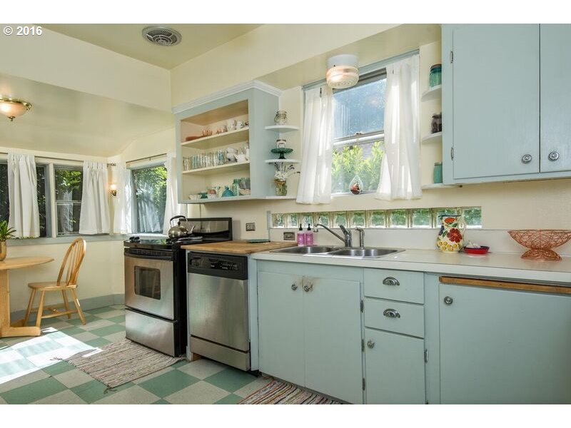 6026 Southwest Vermont Street Portland, OR 97219 - Photo 9 of 24 a kitchen with a stove a sink and a cabinets