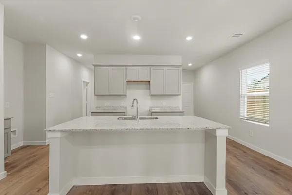 a view of kitchen with kitchen island a sink wooden floor and white appliances