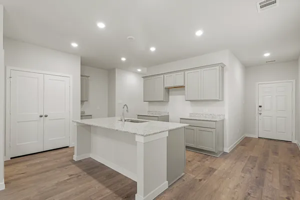 a kitchen with white cabinets appliances and sink