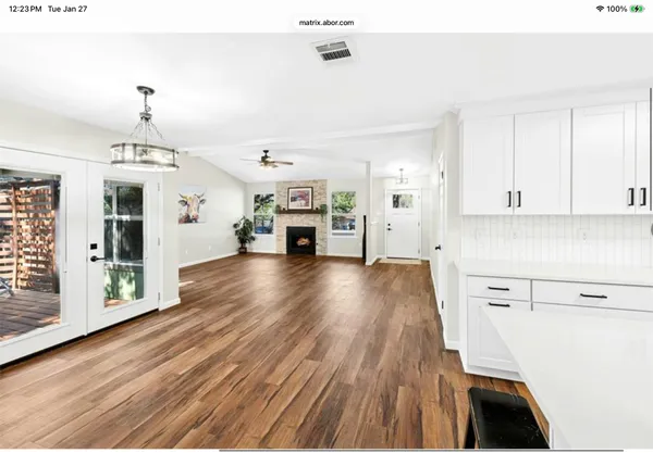 a view of a kitchen with furniture and wooden floor