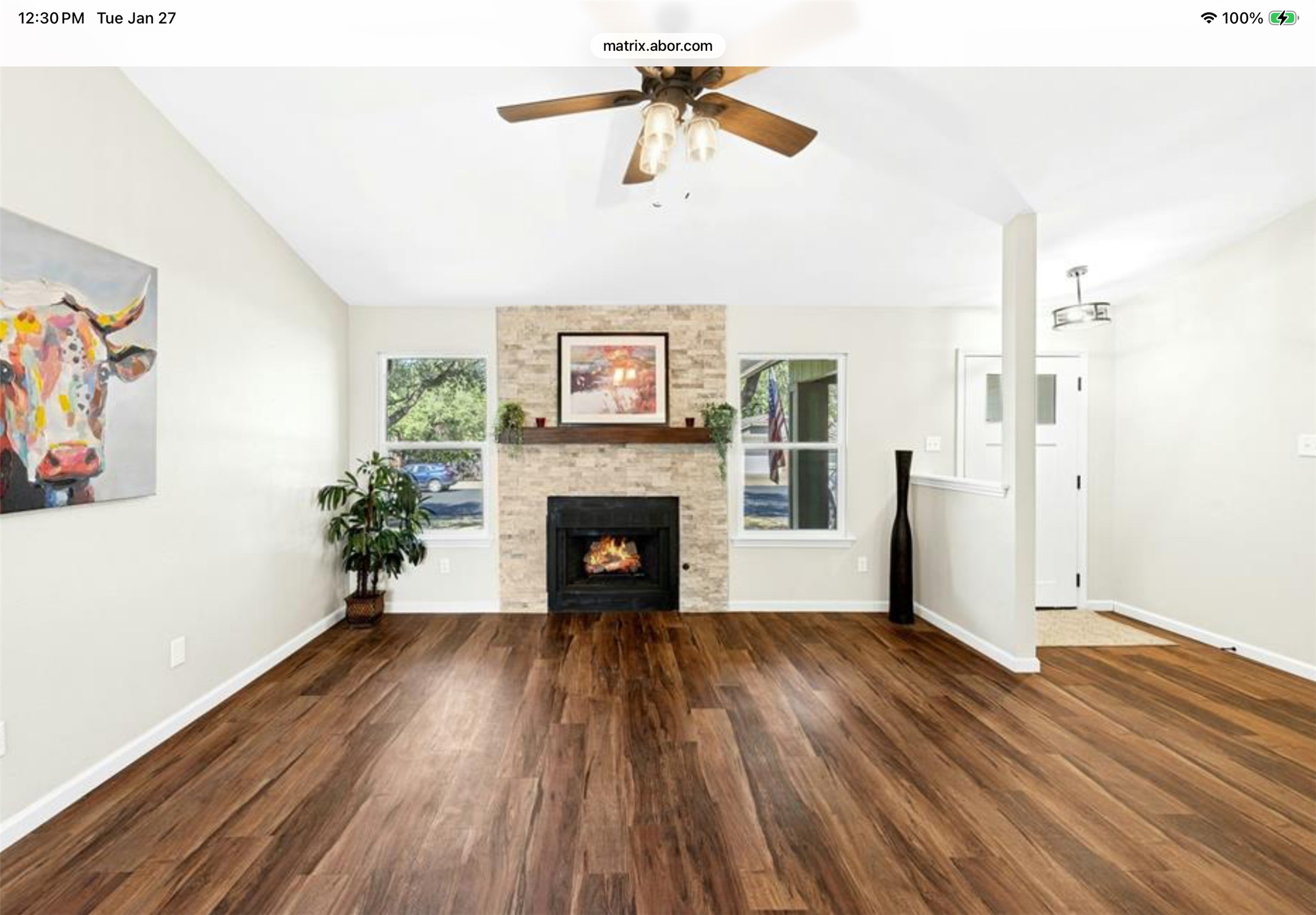 12904 Garfield Lane Austin, TX 78727 - Photo 10 of 31 Unfurnished living room featuring dark wood-style flooring, lofted ceiling, ceiling fan, and a stone fireplace
