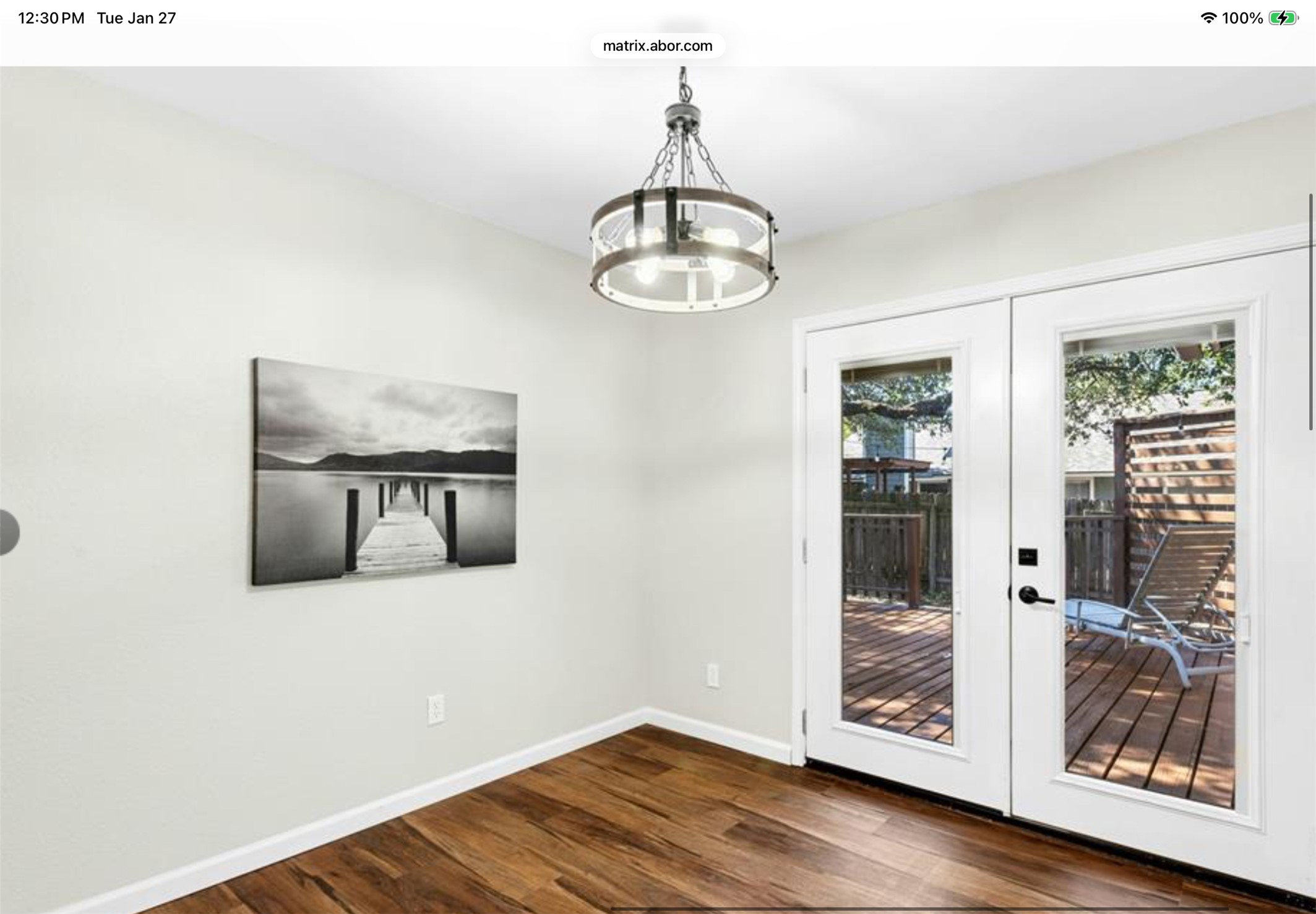12904 Garfield Lane Austin, TX 78727 - Photo 14 of 31 Unfurnished dining area featuring french doors leading to the backyard, LVP wood-style flooring, and new suspended lighti fixture.
