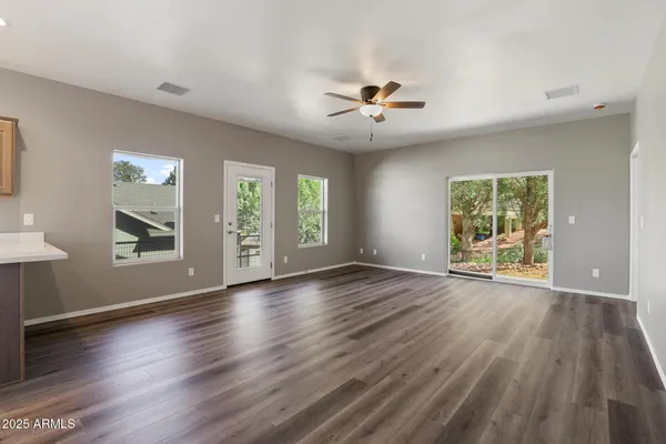 a view of an empty room with a window and wooden floor