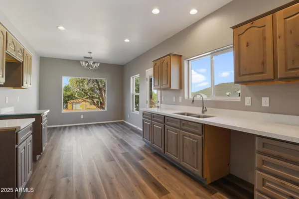 a kitchen with stainless steel appliances granite countertop wooden cabinets a sink and dishwasher with wooden floor