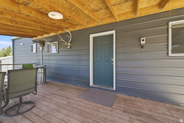 2345 East Frampton Hts Road, Unit 12 Fillmore, UT 84631 - Photo 22 of 31 Expansive wood deck with exposed wood beam ceiling, metal siding exterior, and a paneled entry door