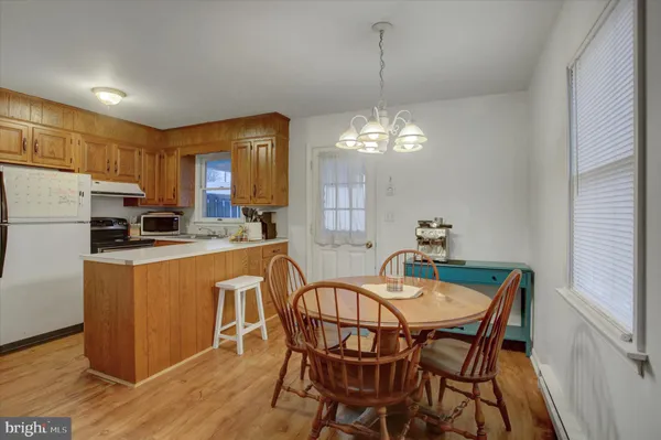 a dining room with furniture a chandelier and wooden floor