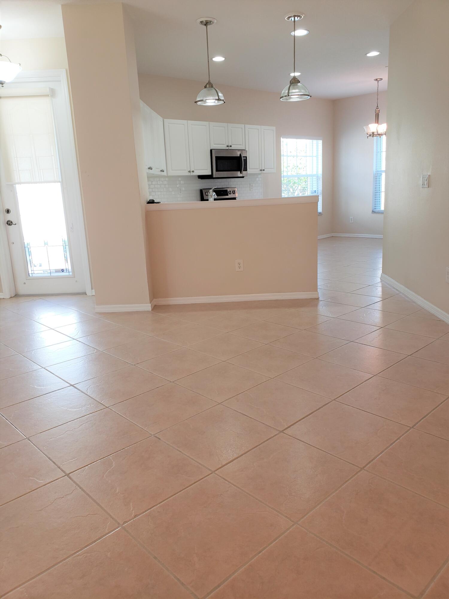 357 Southwest Coconut Key Way Port St. Lucie, FL 34986 - Photo 12 of 56 a view of kitchen with kitchen island white cabinetry and appliances