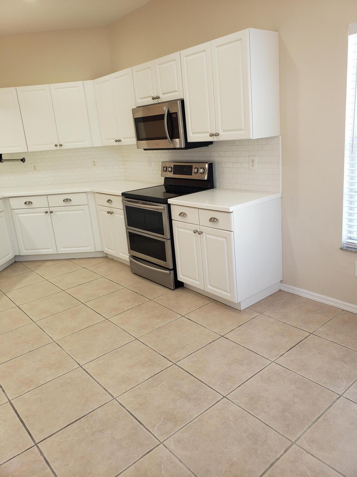 357 Southwest Coconut Key Way Port St. Lucie, FL 34986 - Photo 17 of 56 a kitchen with appliances cabinets and a sink