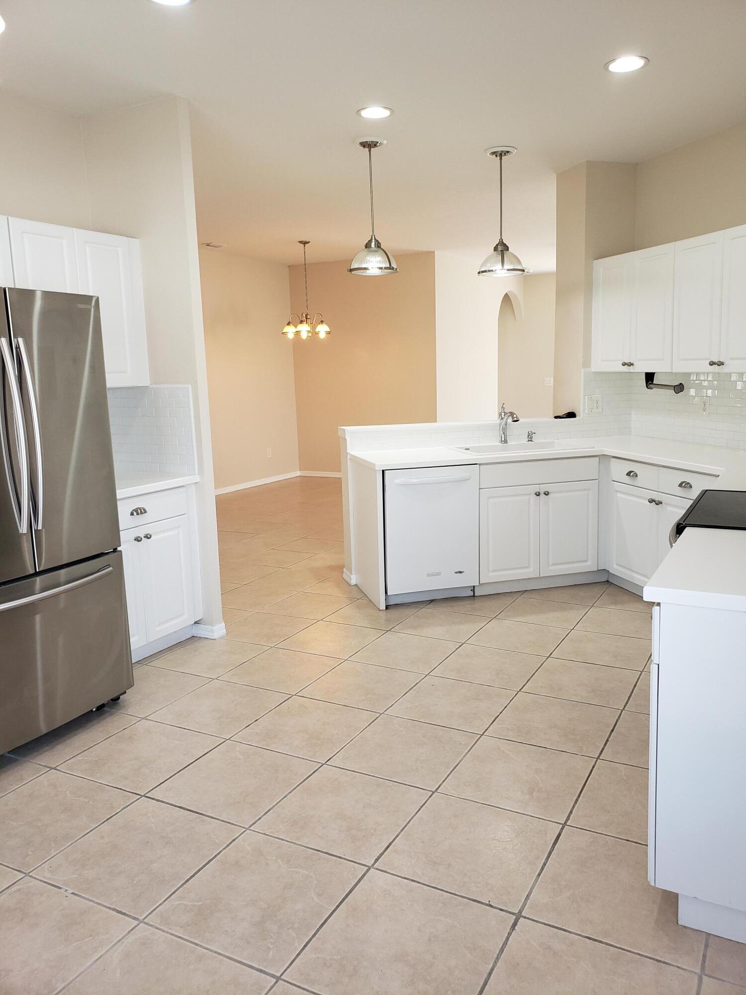 357 Southwest Coconut Key Way Port St. Lucie, FL 34986 - Photo 18 of 56 a large kitchen with a refrigerator a stove a sink and a counter top space