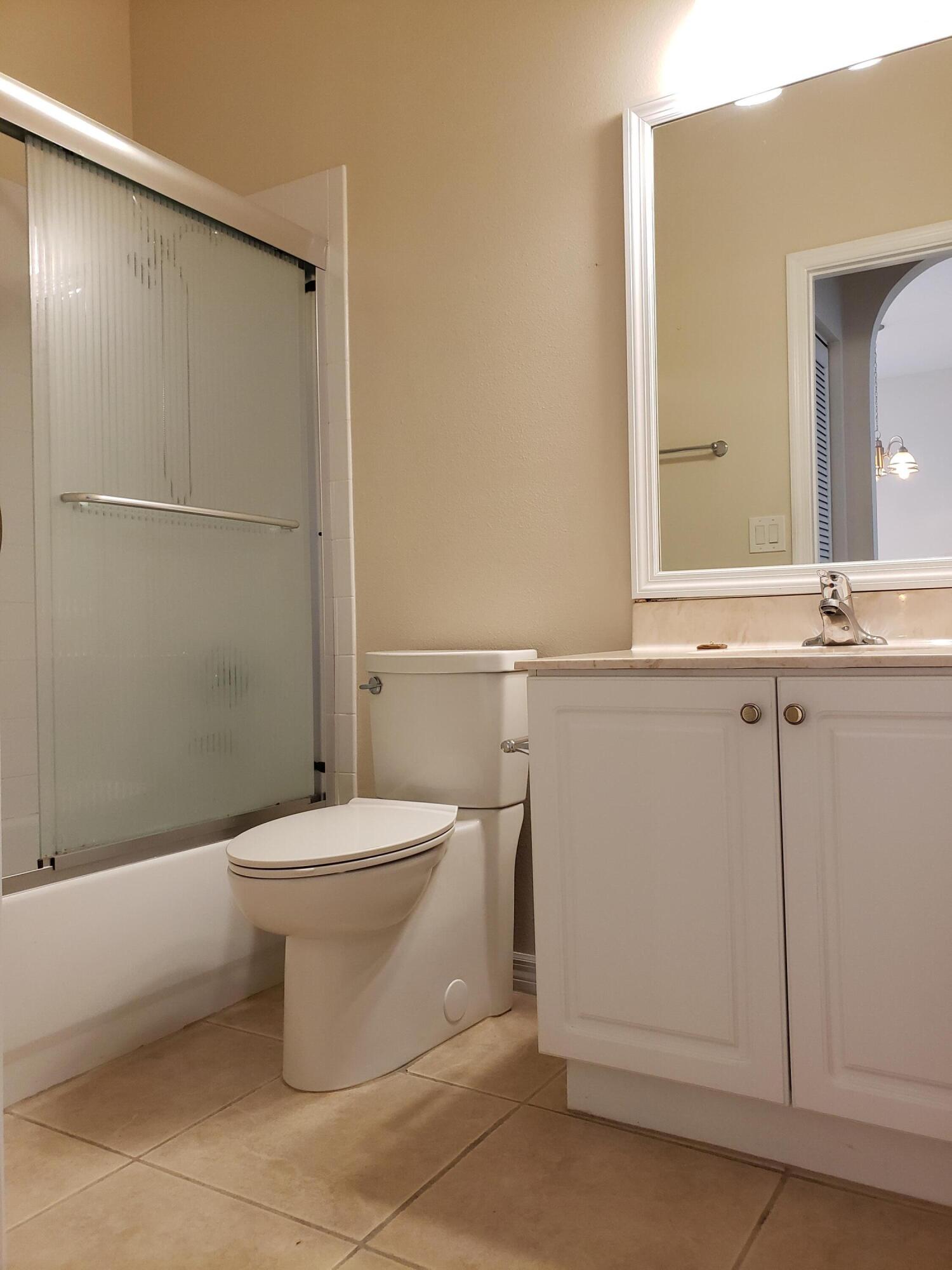 357 Southwest Coconut Key Way Port St. Lucie, FL 34986 - Photo 39 of 56 a bathroom with a toilet a sink and a mirror