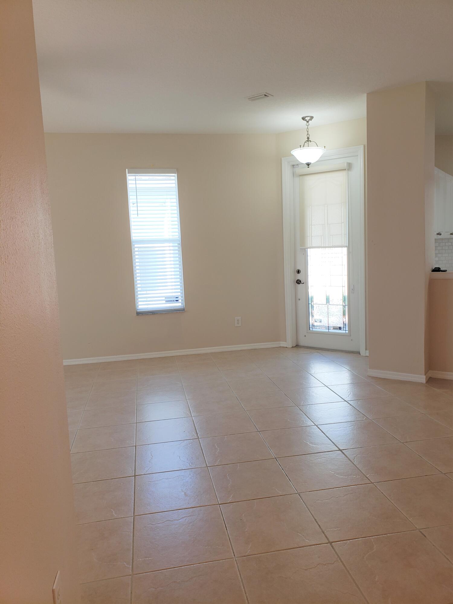 357 Southwest Coconut Key Way Port St. Lucie, FL 34986 - Photo 7 of 56 an empty room with windows and mirror