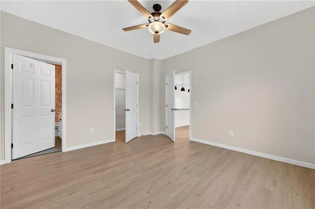 an empty room with closet and a ceiling fan