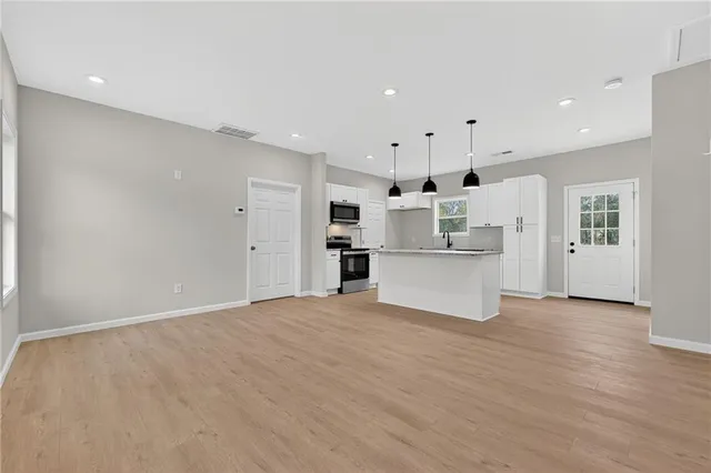 a view of a kitchen with refrigerator and white cabinets
