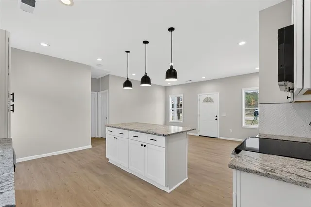 a kitchen with stainless steel appliances granite countertop a sink a stove and a refrigerator