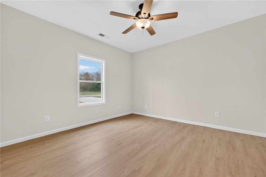 43 Brownlow Drive Northwest Rome, GA 30165 - Photo 10 of 24 an empty room with wooden floor ceiling fan and windows