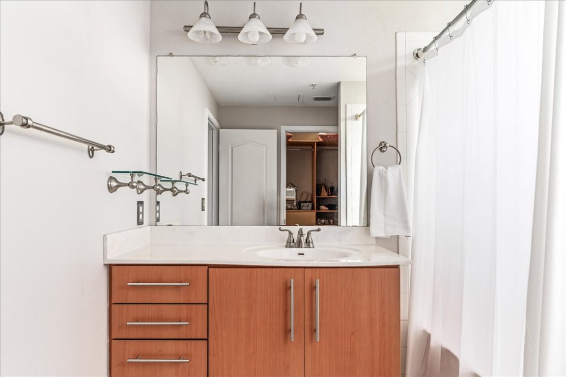 11203 Ranch Road 2222, Unit 1406 Austin, TX 78730 - Photo 16 of 37 a bathroom with a sink and a mirror