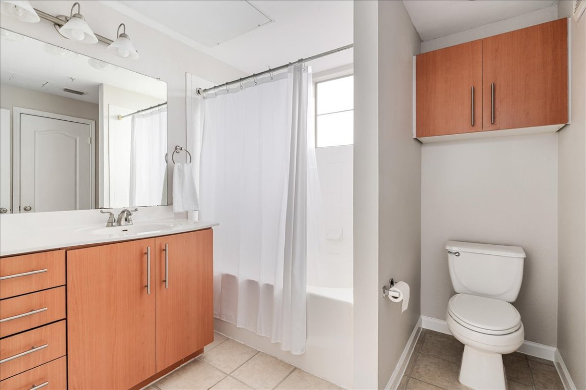 11203 Ranch Road 2222, Unit 1406 Austin, TX 78730 - Photo 17 of 37 a bathroom with a toilet a sink and a mirror