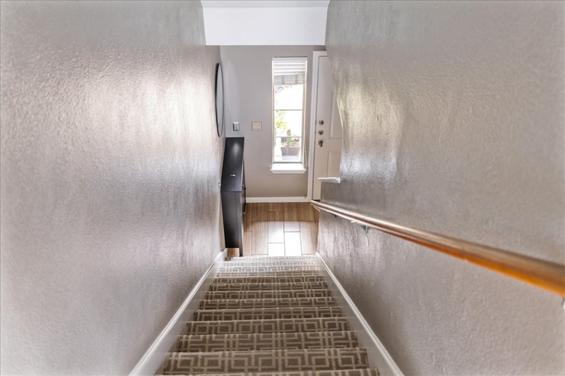 11203 Ranch Road 2222, Unit 1406 Austin, TX 78730 - Photo 23 of 37 a view of a hallway with wooden floor and staircase