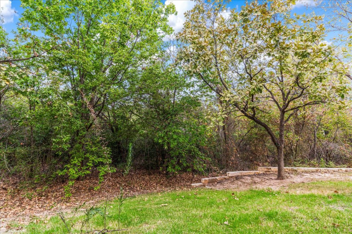 11203 Ranch Road 2222, Unit 1406 Austin, TX 78730 - Photo 33 of 37 a backyard of a house with trees and outdoor seating