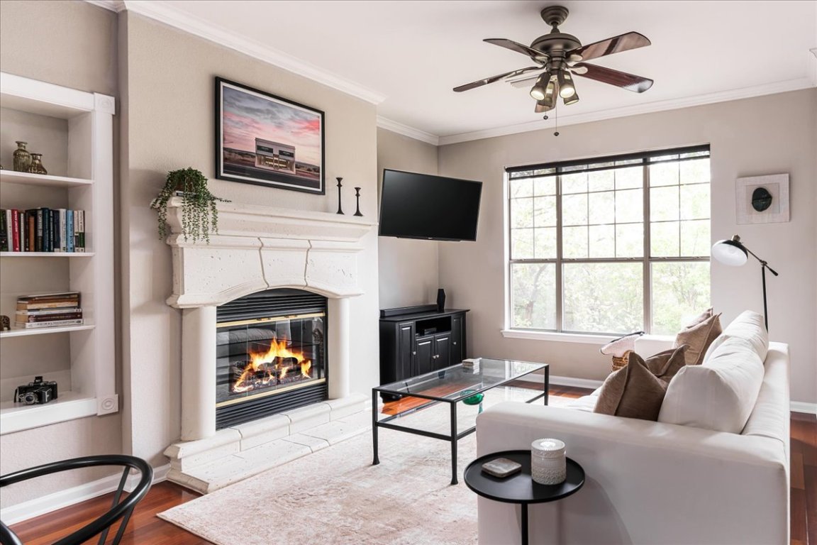11203 Ranch Road 2222, Unit 1406 Austin, TX 78730 - Photo 9 of 37 a living room with furniture a flat screen tv and a fireplace