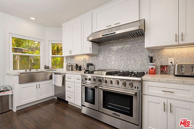 a kitchen with a stove and white cabinets