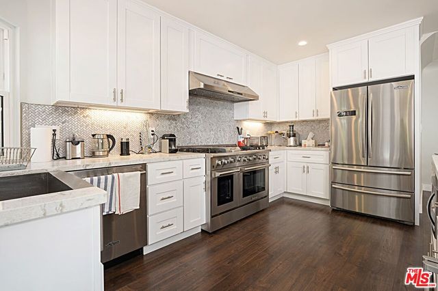 a kitchen with white cabinets and white appliances