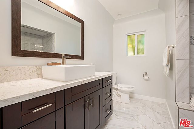 a bathroom with a sink a toilet and mirror