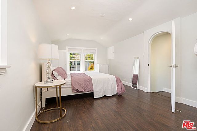 a bedroom with a bed a dresser and a window