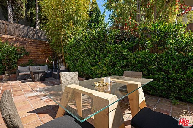 a view of a patio with table and chairs with wooden fence and plants