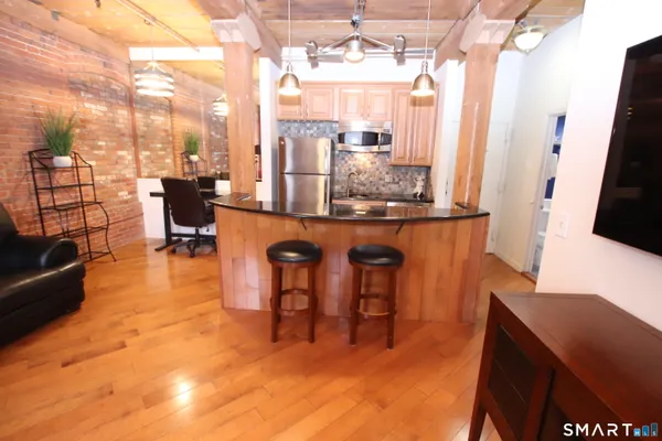 a living room with couches chairs and kitchen view