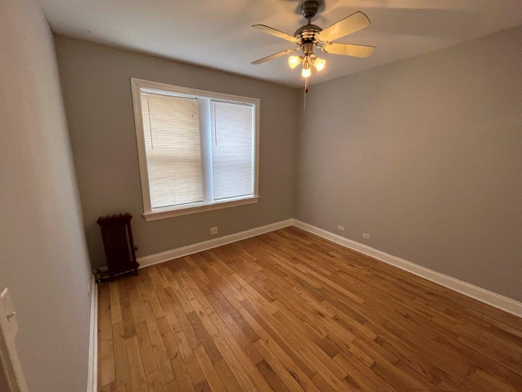 4548 West George Street, Unit 2 Chicago, IL 60641 - Photo 8 of 9 an empty room with wooden floor fan and windows