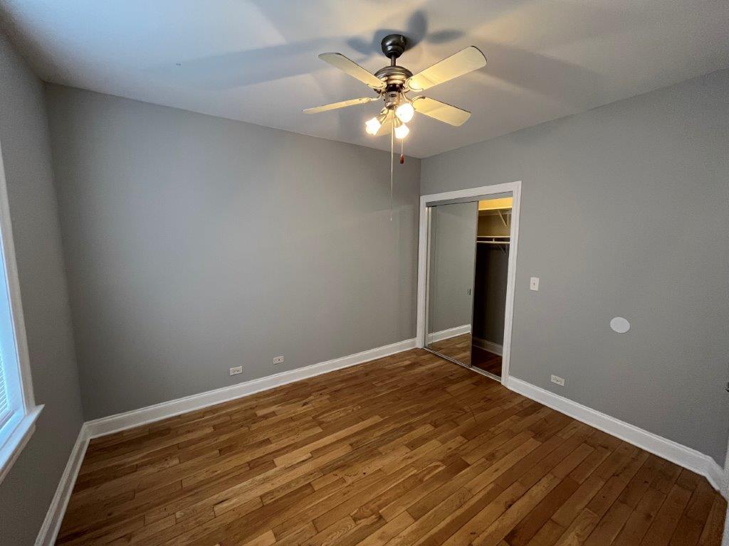 4548 West George Street, Unit 2 Chicago, IL 60641 - Photo 9 of 9 wooden floor in an empty room with a window