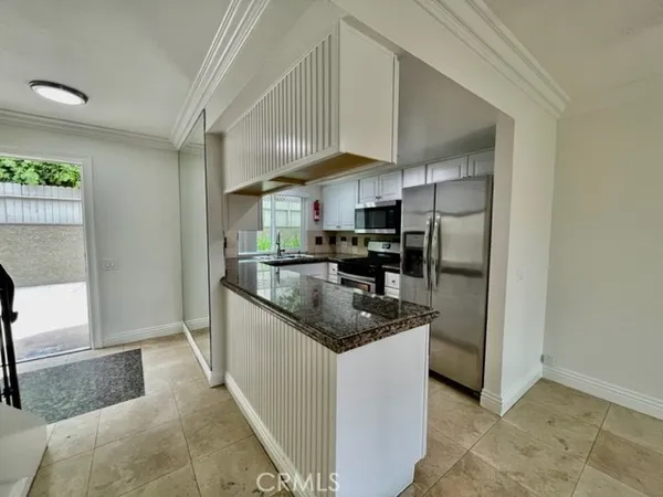 a kitchen with stainless steel appliances granite countertop a sink and a refrigerator