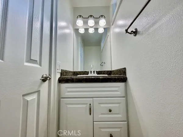 a bathroom with a granite countertop sink a mirror and a vanity