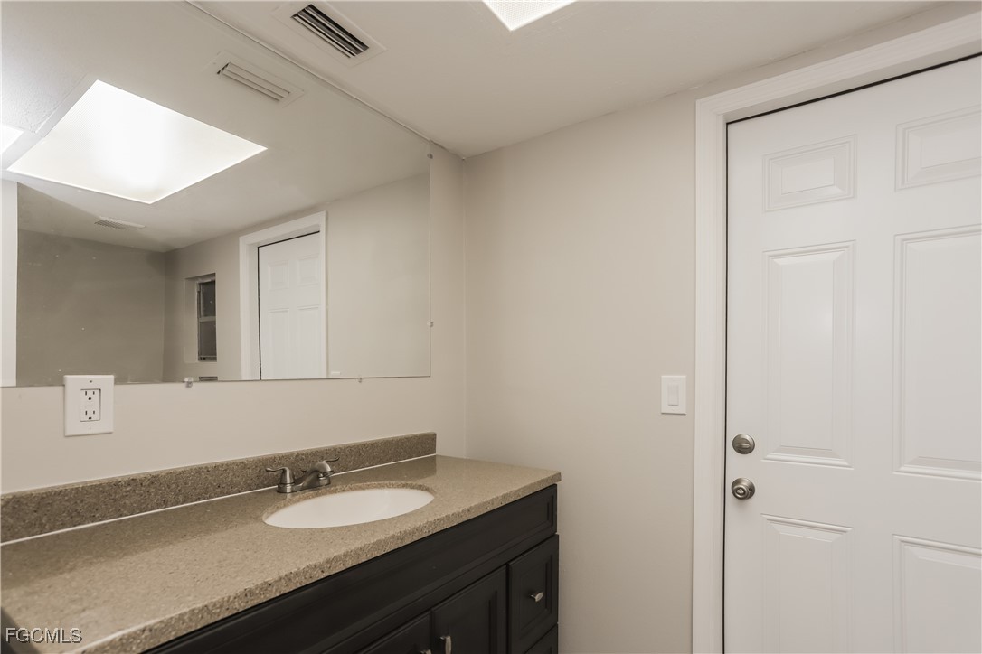 1054 Mohegan Road Venice, FL 34293 - Photo 14 of 16 a bathroom with a granite countertop sink and a mirror