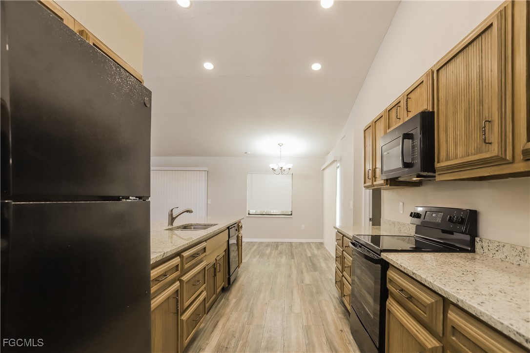 1054 Mohegan Road Venice, FL 34293 - Photo 5 of 16 a kitchen with stainless steel appliances granite countertop a refrigerator a stove top oven a sink and dishwasher