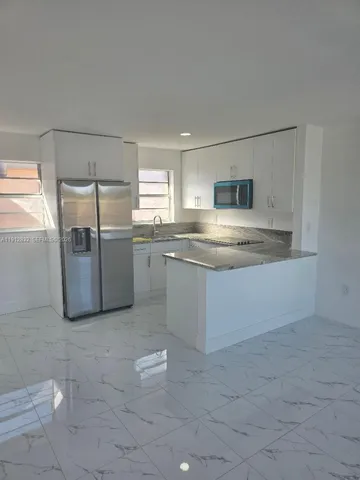 a kitchen with stainless steel appliances granite countertop a refrigerator sink and microwave